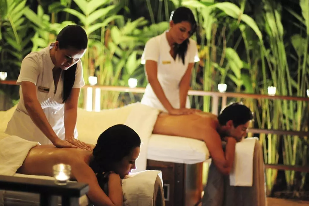 Two people getting a back massage lying down on white towels
