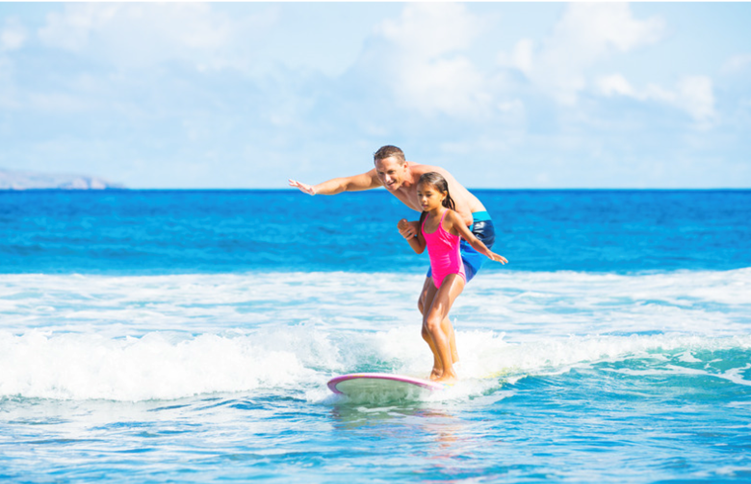 Fatheer and little girl surfing in the water